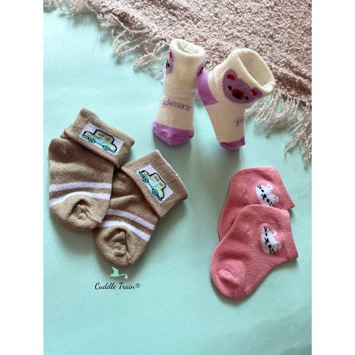 Set of baby socks with cartoon designs on a light blue background