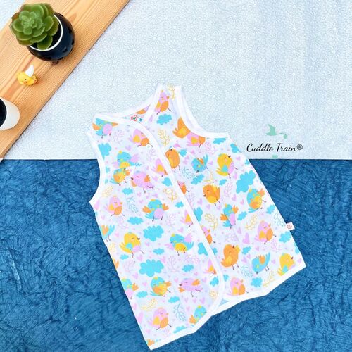Children's sleeveless shirt with colorful pattern on a blue surface, brand 'Cuddle Train' visible.