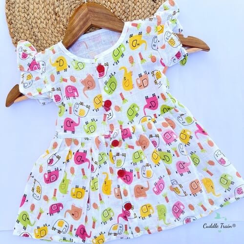 Colorful children's dress with animal pattern on a wooden hanger against a white background