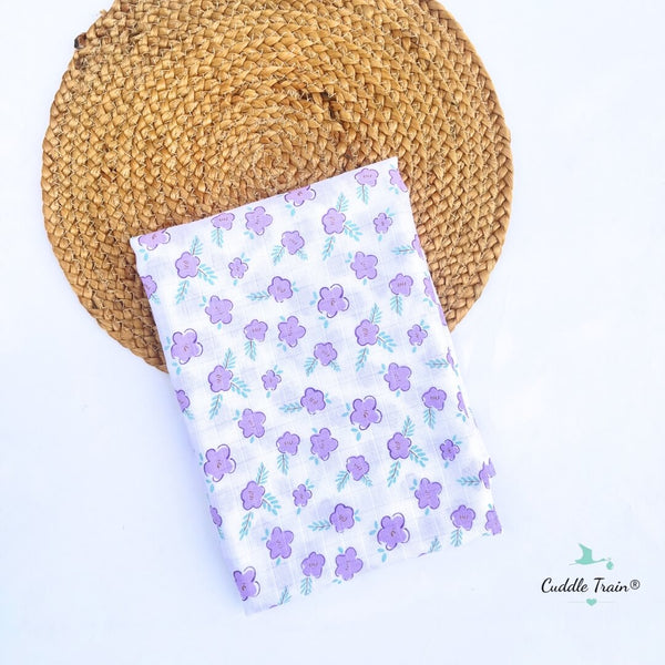 Floral-patterned blanket on a woven mat with 'Cuddle Train' branding.