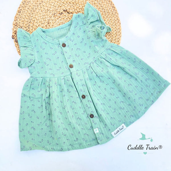 Green dress with floral pattern and brown buttons on a white background, featuring the Cuddle Train brand.