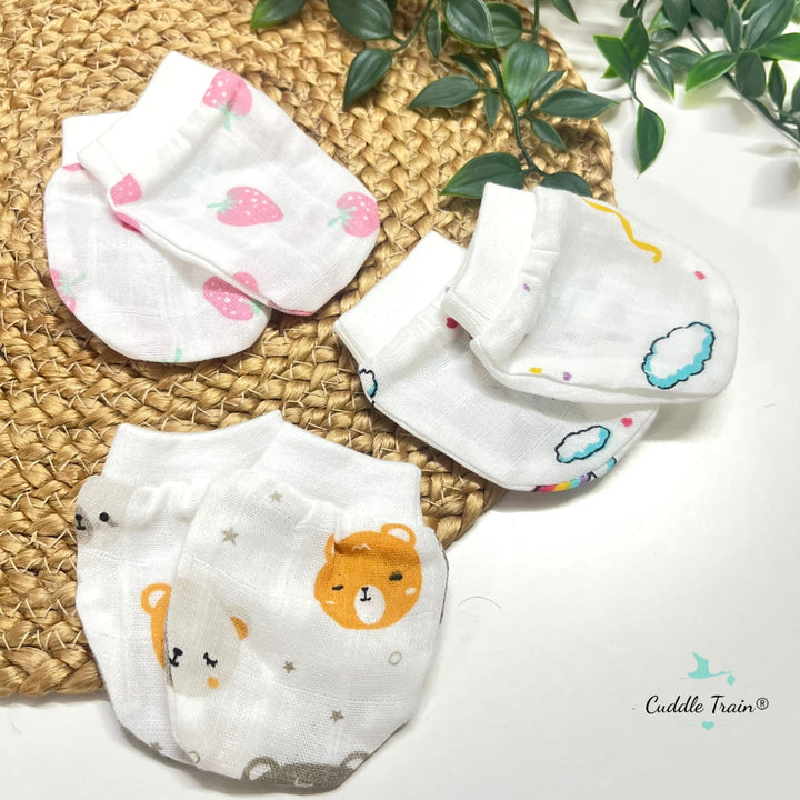 Set of baby socks with animal prints on a woven mat with a plant in the background