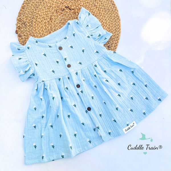 Light blue dress with floral pattern and brown buttons on a white background, featuring the brand 'Cuddle Train'.