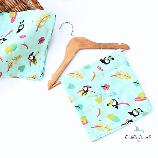Towel fabric with toucan patterns on a wooden hanger against a white background.