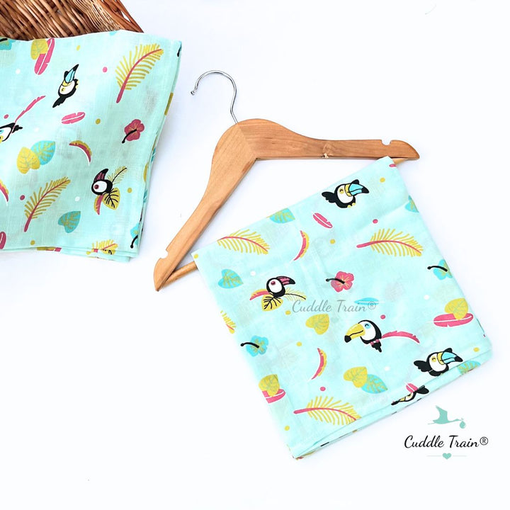 Towel fabric with toucan patterns on a wooden hanger against a white background.